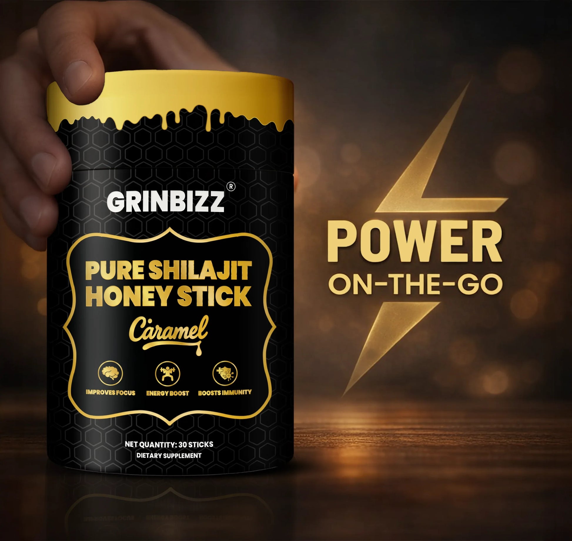 Grinbizz Pure Shilajit Honey Stick packaging with a hand holding it, on a dark background.