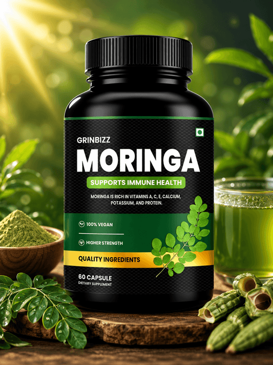 Grinbizz Moringa supplement bottle with green leaves and a glass of juice in the background